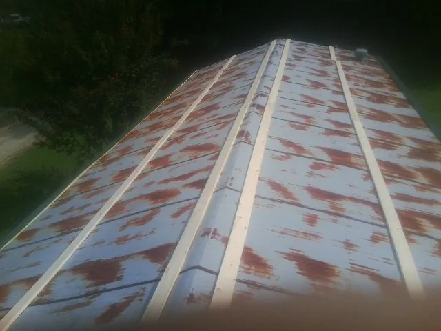 Rusted metal roof panels with new wood purlins before replacement — Storm Damage Roof Repair in Crosby by Roofing Brothers