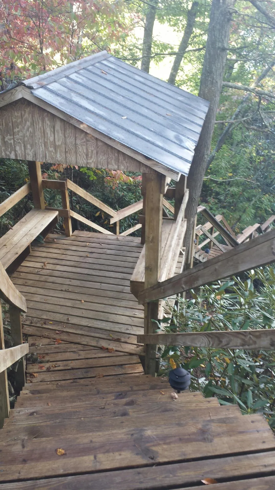 Metal roofed shelter over wooden steps on a wooded walkway — Skylight Repair & Installation work by our crew in Crosby